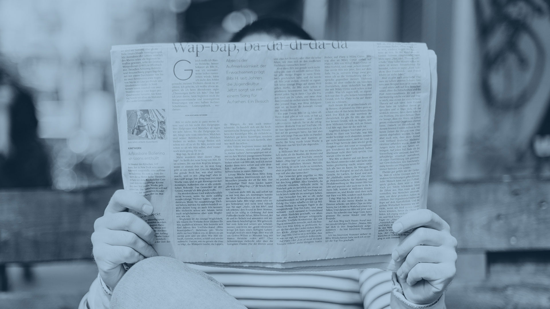 man's face obscured by newspaper